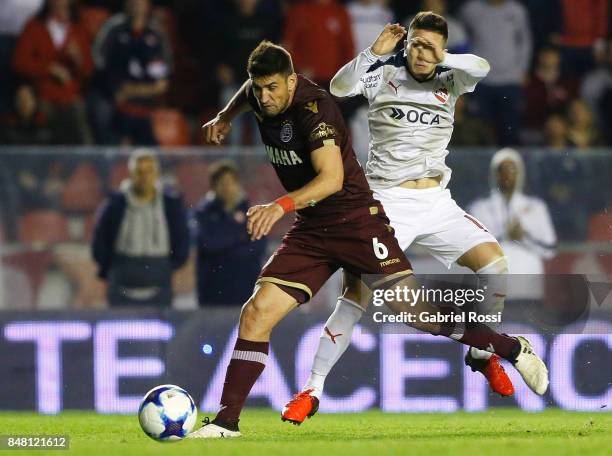 Diego Braghieri of Lanus fights for the ball with Fabricio Bustos of Independiente during a match between Independiente and Lanus as part of the...