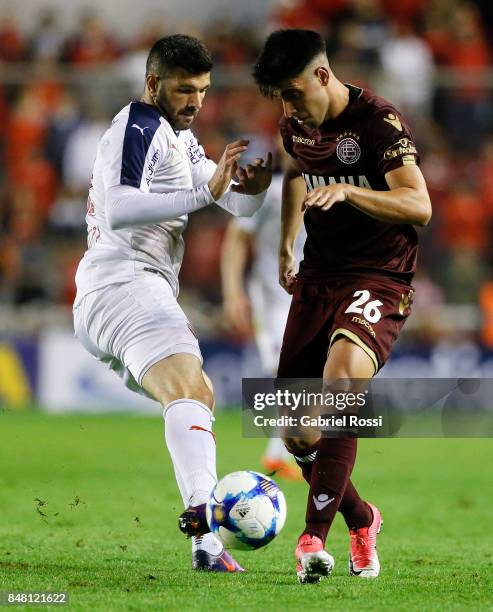 Leonel Di Placido of Lanus fights for the ball with Emmanuel Gigliotti of Independiente during a match between Independiente and Lanus as part of the...