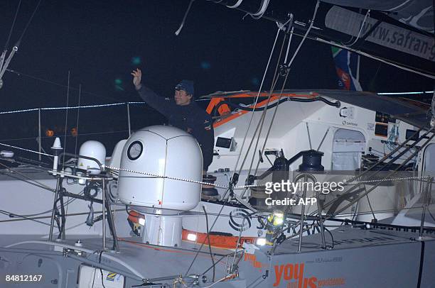 French skipper Marc Guillemot jubilates as he crosses the finish line of the round-the-world solo sailing race on February 16 in the western-French...