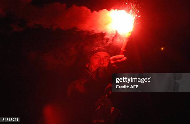 French skipper Marc Guillemot jubilates as he crosses the finish line of the round-the-world solo sailing race on February 16 in the western-French...