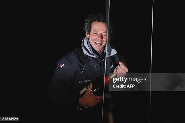 French skipper Marc Guillemot celebrates after crossing the finish line of the round-the-world solo sailing race on February 16 in the western-French...