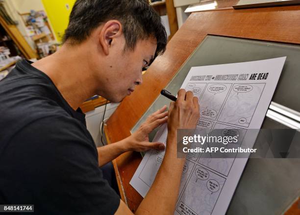 This photograph taken on August 3, 2017 shows Singaporean cartoonist Sonny Liew sketching at his office in Singapore. Singapore cartoonist Sonny Liew...