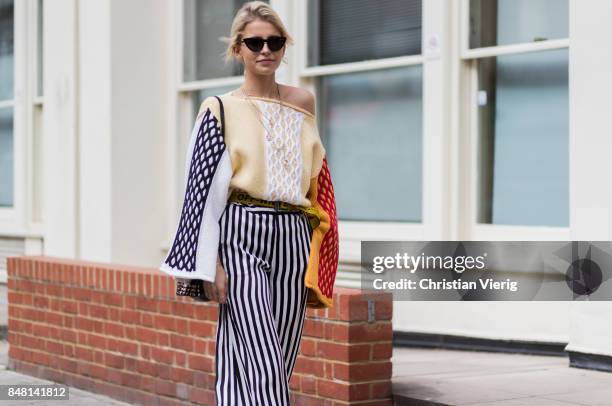 Caroline Daur wearing striped wide leg pants, Off White belt, knit, Prada bag outside JW Anderson during London Fashion Week September 2017 on...