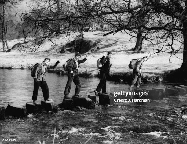 Group of ramblers on stepping stones near Rydal in the Lake District, Cumbria, 1957.