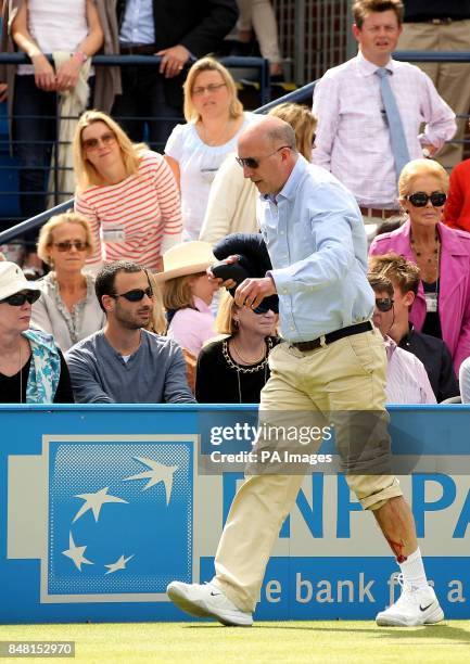 Line judge Andrew McDougall walks away following an injury caused after Argentina's David Nalbandian kicking an advertising board causing a cut to...