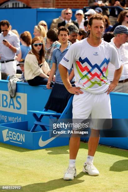 Argentina's David Nalbandian stands dejected after being disqualified from the Final after he kicked an advertising board and caused an injury to...