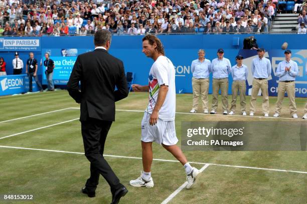 Argentina's David Nalbandian talks to Tournament Director Chris Kermode after being disqualified from the Final for kicking an advertising board and...