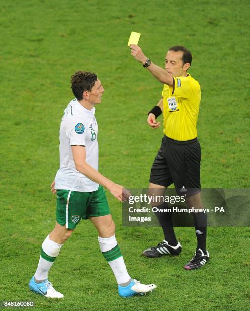 Rep of Ireland's Keith Andrews is shown a yellow card by referee Cuneyt Cakir