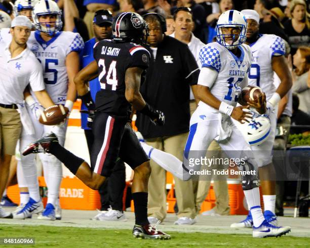 Quarterback Stephen Johnson of the Kentucky Wildcats sticks out his tongue at defensive back DJ Smith of the South Carolina Gamecocks as he runs out...