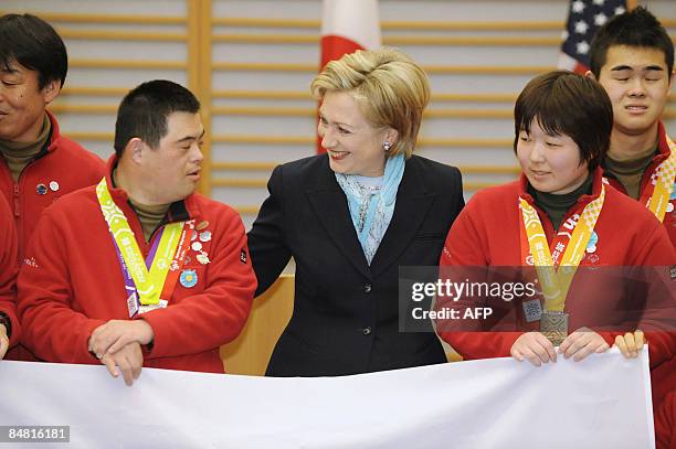 Secretary of State Hillary Clinton, smiles as she poses for photos with athletes of the Special Olympics World Winter Games upon her arrival at...