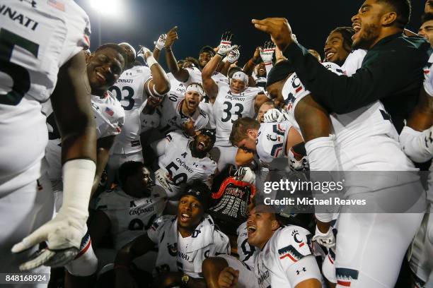 The Cincinnati Bearcats celebrate with the Victory Bell after defeating the Miami Ohio Redhawks 21-17 at Yager Stadium on September 16, 2017 in...