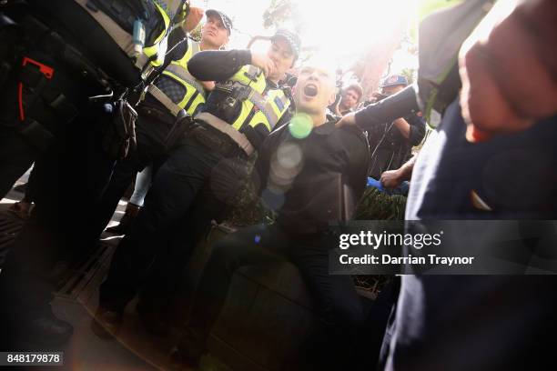 Masked protestor is detained by police as they enforce laws surrounding the wearing of masks to cover the face at rallies on September 17, 2017 in...