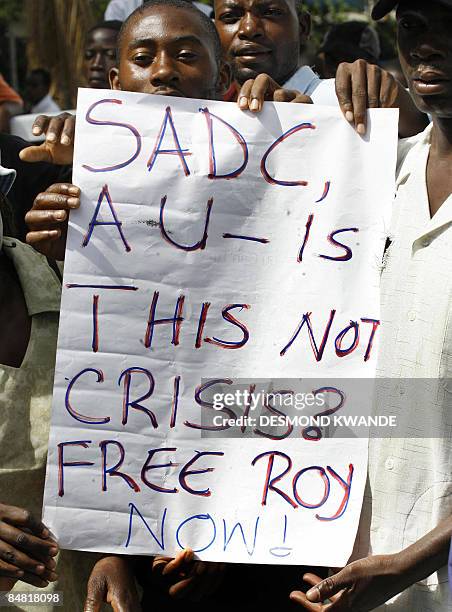 Zimbabwean opposition supporter holds a placard outside Mutare Magistrate court, 270 kms east of Harare, on February 16, 2009 where oppositon...