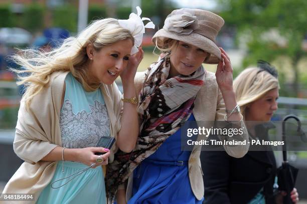 Ladies clutch their hats against the wind as they arrive during day four of the 2012 Royal Ascot meeting at Ascot Racecourse, Berkshire.