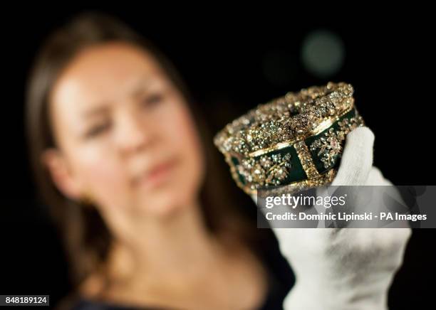 Exhibition Curator Caroline de Guitaut holds a table snuff box owned by Frederick the Great of Prussia, incorporating nearly 3,000 diamonds, which...