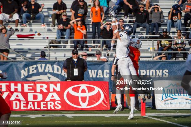 Defensive back Jaden Sawyer of the Nevada Wolf Pack jumps to try for an interception over wide receiver Hagen Graves of the Idaho State Bengals...