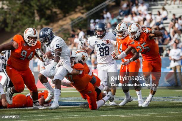 Running back Jaxson Kincaide of the Nevada Wolf Pack is taken down by the Idaho State Bengals at Mackay Stadium on September 16, 2017 in Reno, Nevada.