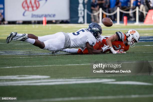 Defensive back Dameon Baber of the Nevada Wolf Pack lands on top of wide receiver Michael Dean of the Idaho State Bengals after a near interception...