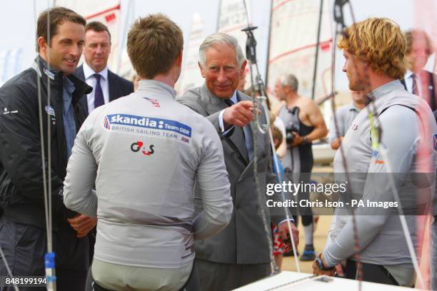 The Prince of Wales, with the British Olympic 49er sailors, Stevie Morrison and Ben Rhodes as Ben Ainslie looks on during a visit to the Weymouth and...
