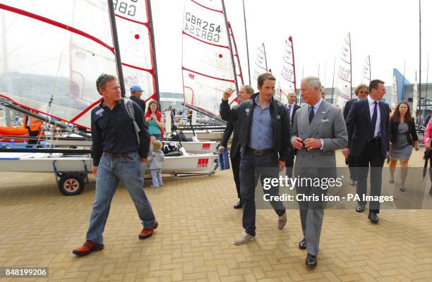 The Prince of Wales , walks with British Olympic triple gold medal winning sailor Ben Ainslie and Squad Manager Stephen Park during a visit to the...
