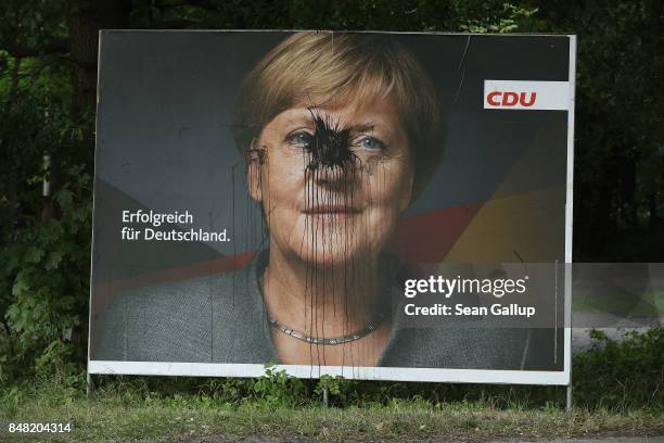 Vandalized billboard showing German Chancellor and Christian Democrat Angela Merkel and that reads: "Successful for Germany" stands on September 16,...