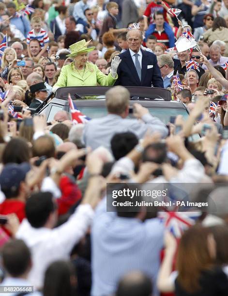 Queen Elizabeth II and the Duke of Edinburgh wave to the crowds in the grounds of Stormont in Belfast, during a two-day visit to Northern Ireland as...