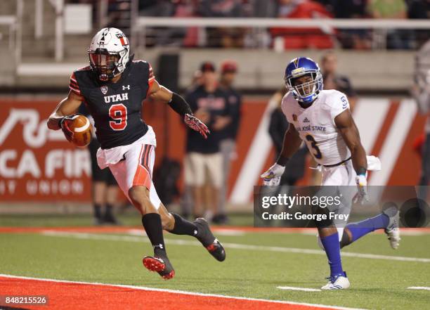 Wide receiver Darren Carrington II of the Utah Utes runs past cornerback Jermaine Kelly of the San Jose State Spartans for a touchdown during the...