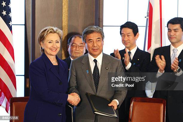 Secretary of State Hillary Clinton and Minister for Japan's Foreign Affairs Hirofumi Nakasone shake hands after signing an agreement during their...