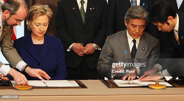 Secretary of State Hillary Clinton and Minister for Japan's Foreign Affairs Hirofumi Nakasone prepare to sign an agreement during their meeting at...