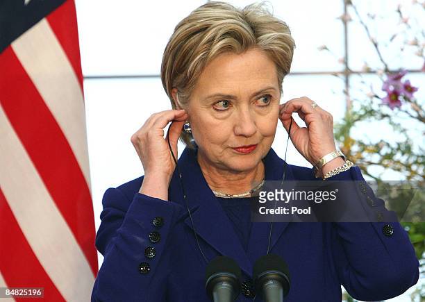 Secretary of State Hillary Clinton puts in her earpieces during a press conference with Minister for Japan's Foreign Affairs Hirofumi Nakasone at the...