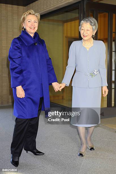 Secretary of State Hillary Rodham Clinton holds hands with Japan's Empress Michiko upon arriving to attend a tea party at Imperial Palace in Tokyo on...