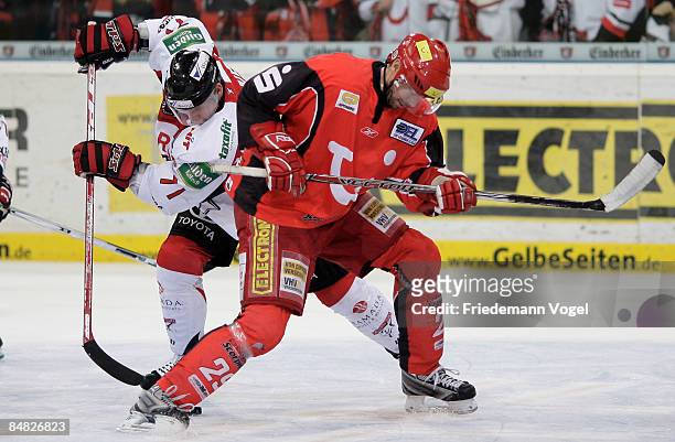 Tore Vikingstad of Hannover and Dave McLlwain of Koelner Haie compete for the puck during the DEL Bundesliga game between Hannover Scorpions and...