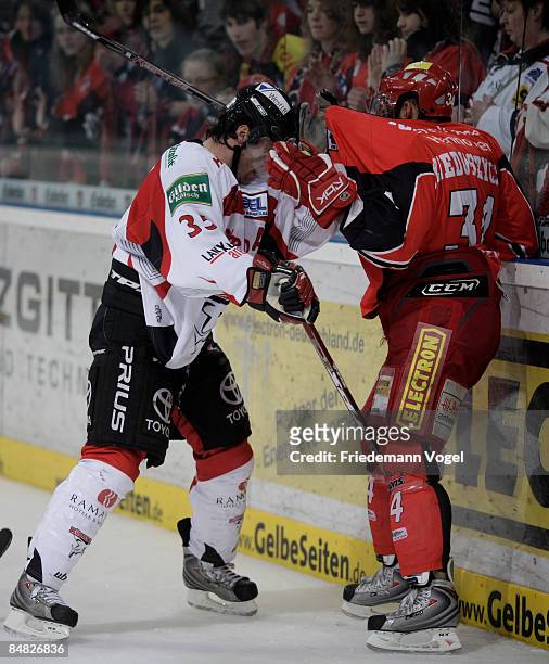 Matt Dzieduszycki of Hannover and Andreas Renz of Koelner Haie compete for the puck during the DEL Bundesliga game between Hannover Scorpions and...