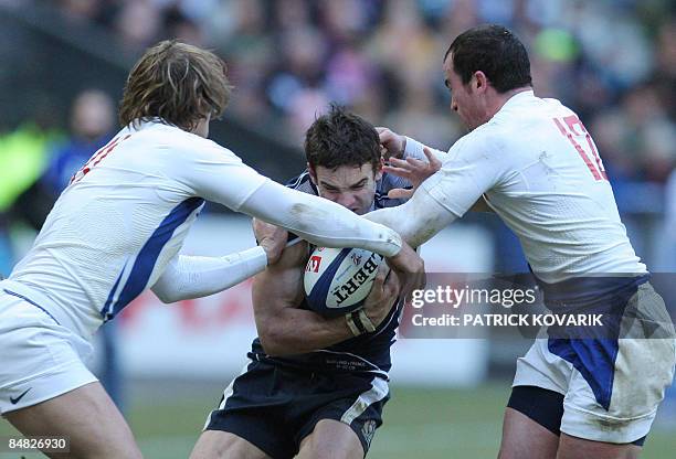 Scottish wing Thom Evans tries to escape from French center Benoit Baby during their six Nations rugby union match France versus Scotland on February...