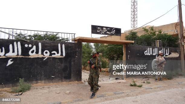 Picture taken during a press tour provided by the Russian Armed Forces on September 15, 2017 shows Syrian soldiers standing outside a building which...