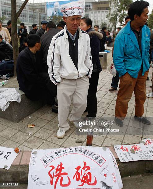 Migrant worker wearing a hat printed with job seeking ad seeks employment at the Jinjiang District Human Resources Market on February 17, 2009 in...