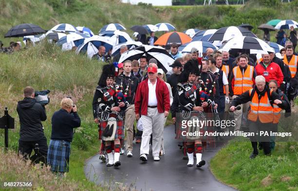 Donald Trump is followed by his guests as he officially opens the Trump International Golf Links golf course near Aberdeen this morning.