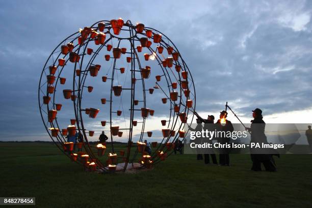 Artists light large candles near the ancient stones at Stonehenge near Salisbury, Wiltshire as French artists Compagnie Carabosse present Fire Garden...