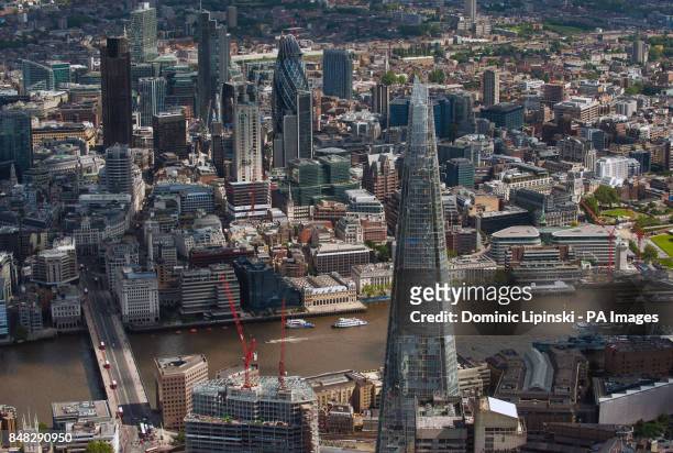 Aerial view of central London, showing the Shard , and the City financial district, including the Swiss Re Tower, also known as the Gherkin .
