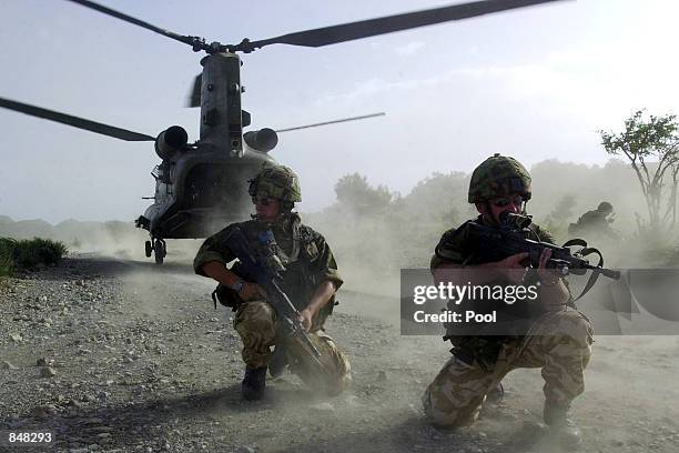 British Royal Marines of 45 Commando take up defensive positions as they disembark a chinook helicopter while conducting vehicle stops and searches...
