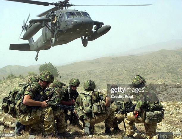 Royal Marines of Whisky company 45 commando prepare to board a US Army Black Hawk helicopter during vehicle stops and searches on June 26, 2002 near...