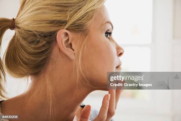 women checking face - kin in de hand stockfoto's en -beelden