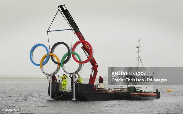 Engineers install a set of Olympic rings in the sea at the Weymouth and Portland Sailing Academy, Weymouth.