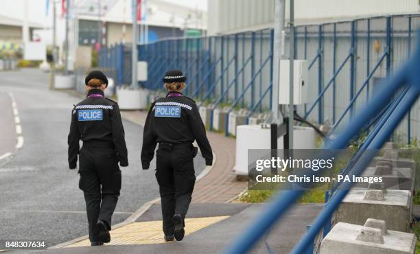 Police officers walk the perimeter fence at the Weymouth and Portland Sailing Academy, Weymouth.