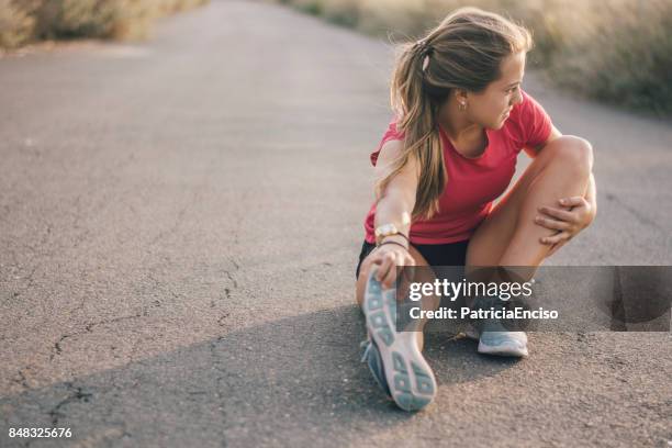 mujer joven antes de ejercicios de estiramiento - exercice physique fotografías e imágenes de stock