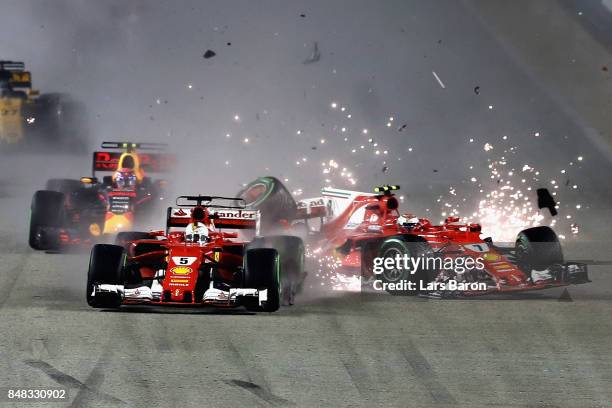 Sebastian Vettel of Germany driving the Scuderia Ferrari SF70H and Kimi Raikkonen of Finland driving the Scuderia Ferrari SF70H collide at the start...