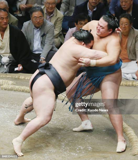 Ozeki Goeido forces komusubi Tamawashi out of the dohyo ring during the eighth day of the Autumn Grand Sumo Tournament at Ryogoku Kokugikan in Tokyo...