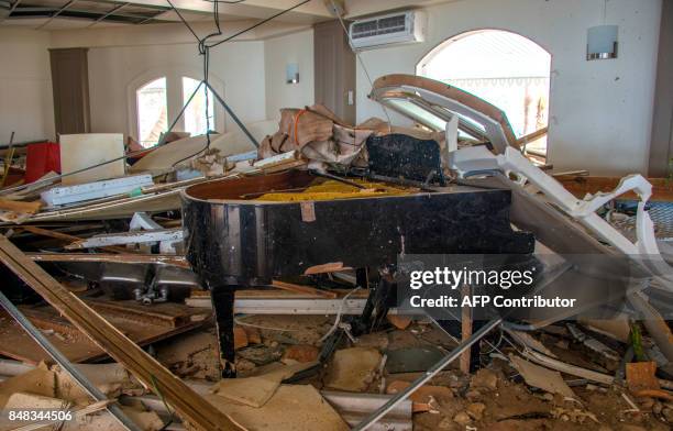 Picture taken on September 16, 2017 in the Sandy Ground neighborhood of Marigot shows a broken piano in the Beach Plaza hotel, where French gendarmes...