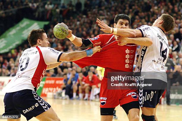 Nenad Vuckovic of Melsungen challenges for the ball with Johnny Jensen and Thomas Mogensen of Flensburg during the Bundesliga match between SG...
