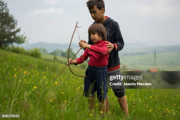 two boys with homemade bow and arrow - arrows landscapes stock pictures, royalty-free photos & images